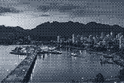 Mountains above a harbour and city lights at dusk